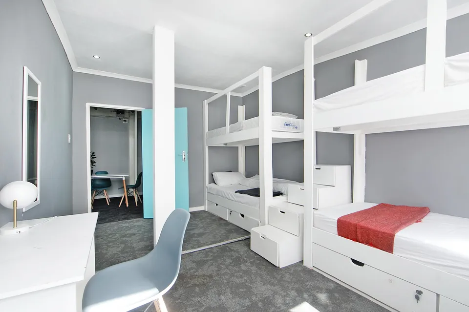 Shared room with white bunk beds and a desk