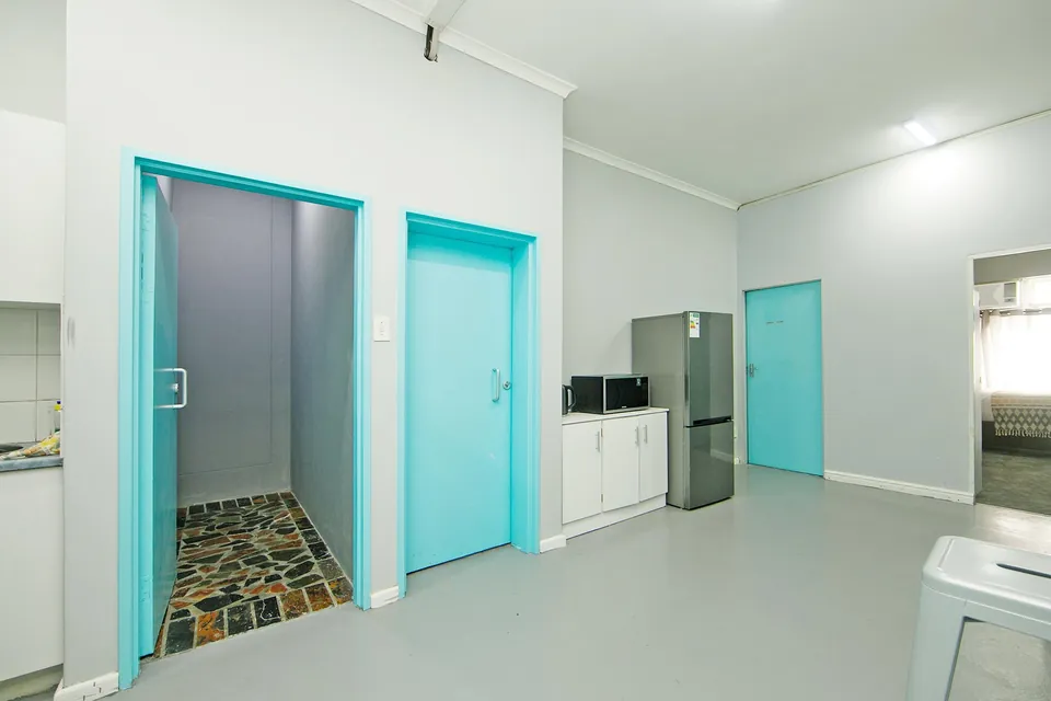 Hallway with turquoise doors and a kitchenette